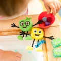 NOWY Glo Pals, Postać do kąpieli Alex - zestaw z dwiema kostkami sensorycznymi świecącymi w wodzie
